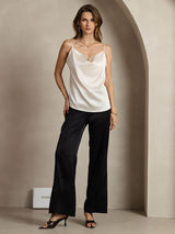 White silk spaghetti strap cowl neck camisole with black wide-leg pants