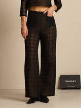 Black high-waist wide-leg silk pants with textured grid pattern and front pockets