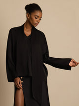Black silk V-neck blouse with asymmetrical tie detail and long sleeves