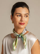 Woman wearing a 100% mulberry silk patterned square scarf, tied at the neck