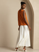Women’s orange sleeveless silk cowl neck top with white skirt