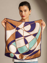 Woman holding geometric mulberry silk square scarf in purple, gold, and mint