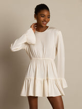 Model wearing ivory silk A-line dress with ruffle sleeves and tiered skirt