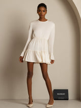 Model wearing ivory silk A-line mini dress with long sleeves and ruffle hem