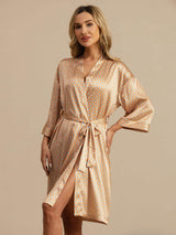 Woman wearing orange heart geo printed silk kimono robe with belted waist