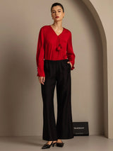 Model wearing red silk-wool straight-leg pants with drawstring and side pockets