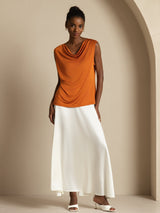 Women’s sleeveless silk cowl neck top in orange, styled with a white skirt