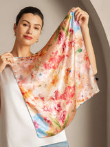 Woman holding 53x53cm mulberry silk floral square scarf with pastel floral print