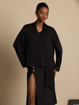 Black silk asymmetrical tie V-neck blouse with long sleeves and side-slit skirt styling
