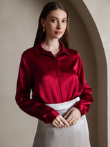 Woman wearing a red silk long sleeve lapel collar blouse with a concealed button front
