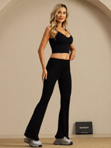 Black high-waisted silk flare pants on model with matching crop top
