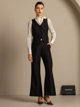 Model wearing black silk-wool blend V-neck vest with button detail and matching wide-leg pants