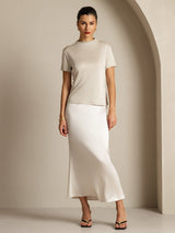 Model wearing ivory pure silk short sleeve mock neck T-shirt with satin midi skirt
