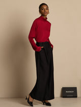 Model wearing red silk turtle neck long sleeve top with black wide-leg pants
