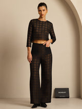 Model wearing black textured grid silk wide-leg pants with pockets