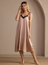 Model in pink silk midi nightgown with black contrast V-neck and spaghetti straps