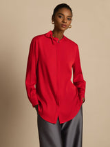 Woman wearing red silk stand collar blouse with bow detail and long sleeves