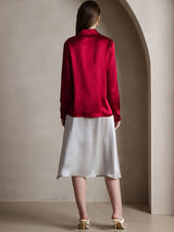 Back view of a woman wearing a red silk long sleeve lapel collar blouse