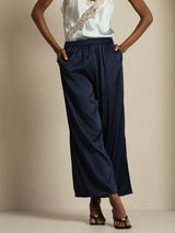 Model wearing navy silk wide leg split pants with elastic waist