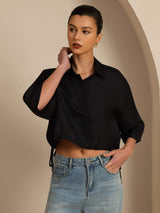Black cropped silk blouse with lapel collar, half sleeves and drawstring hem, styled with jeans