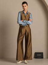 Model wearing brown wide-leg silk-wool blend pants with blue shirt and vest