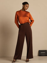 Model wearing orange silk blouse with brown wide-leg high-waist business casual pants