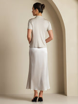 Back view of model wearing a light silk A-line maxi skirt with a short-sleeve top