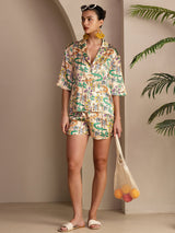 Woman wearing multicolor crocodile print silk pajama set with short-sleeve button-up shirt and shorts