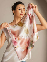 Woman holding 100% mulberry silk floral square scarf with pink trim
