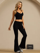 Black high-waisted silk flare pants worn with matching crop top