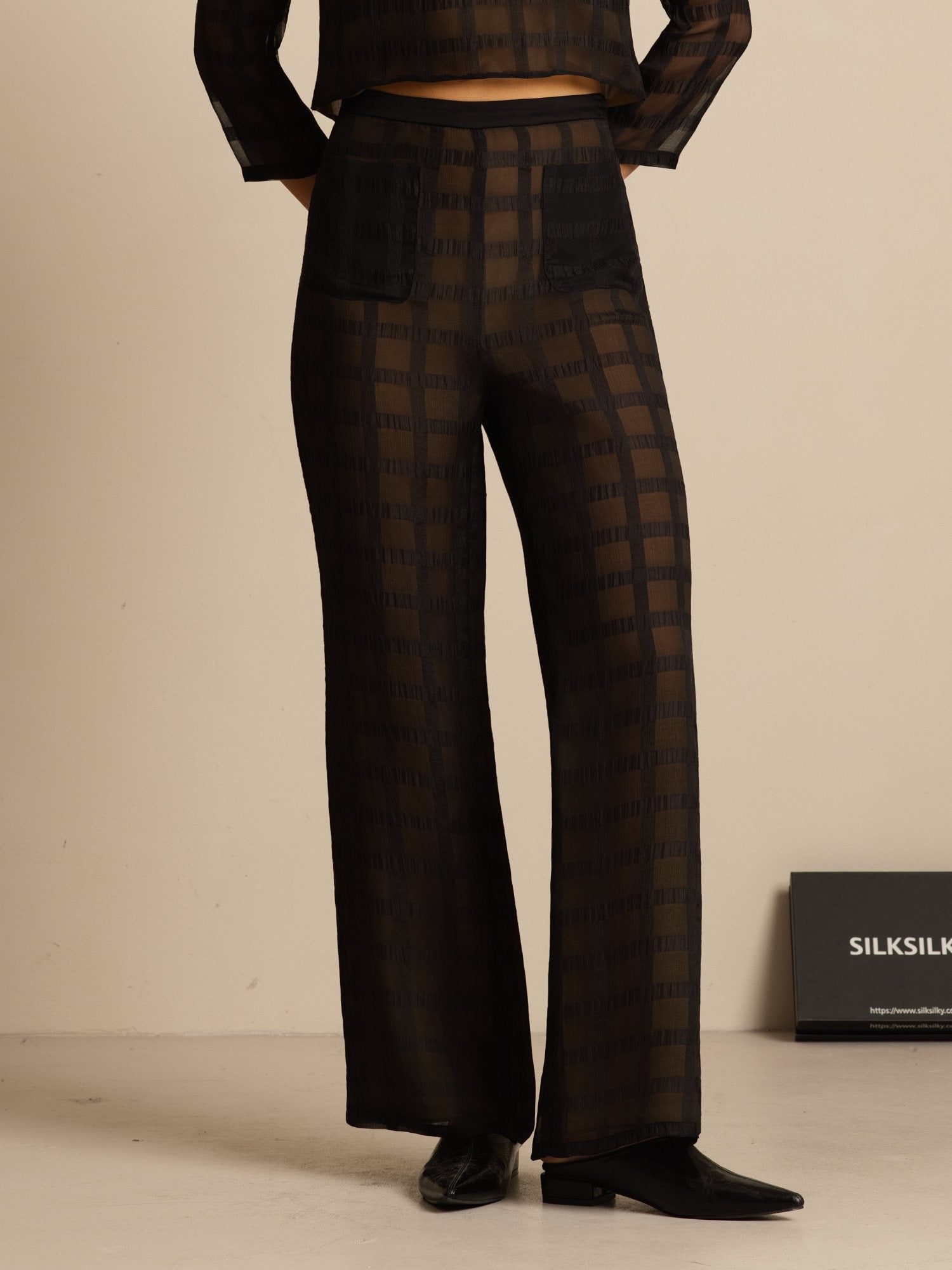 Black silk high-waist wide-leg pants with textured grid pattern and pockets