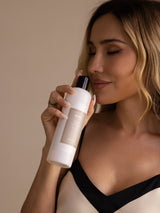 Woman holding SilkSilky enzyme silk laundry detergent bottle