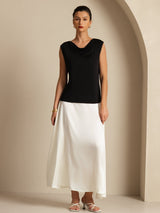 Women's black sleeveless silk jersey cowl neck top styled with white skirt