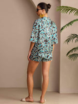 Back view of botanical print silk pajama set in blue, black, and white, with short sleeves and shorts