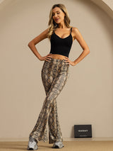 Woman wearing high-waisted snake print silk flare pants with black crop top