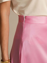 Pink silk A-line maxi skirt with side zip and lined waist, shown with cream top