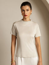Woman wearing a cream pure silk short sleeve mock neck top