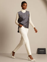 Gray silk-wool blend women's vest with button pockets, styled over white turtleneck and pants