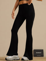 Black high waisted silk flare pants on model, full length, slim fit, bell bottom style
