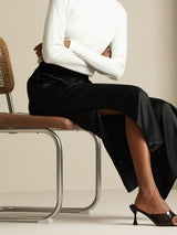 Black silk wide leg split pants on model with white top and heels