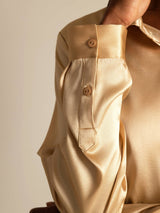 Gold silk long sleeve shirt cuff with button detail and smooth satin finish