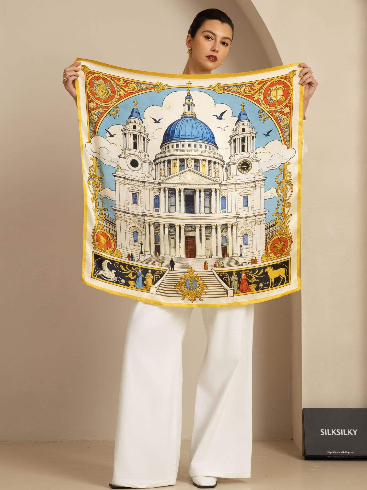 White silk square scarf with cathedral print and yellow border, held by model