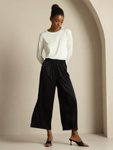 Model wearing black silk wide leg pants with elastic waist and white top