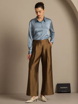Model wearing blue silk blouse with brown wide-leg silk-wool blend pants and side pockets