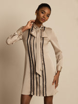 Beige silk tie-neck short shirt dress with vertical pleats and lace stripe accents