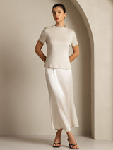 Woman wearing ivory pure silk short sleeve mock neck top with matching midi skirt