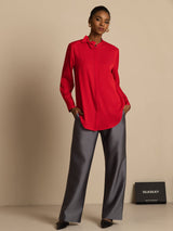 Red long sleeve silk blouse with stand collar and bow tie, paired with gray pants