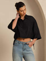 Black silk cropped blouse with drawstring hem, half sleeves, and lapel collar, styled with jeans