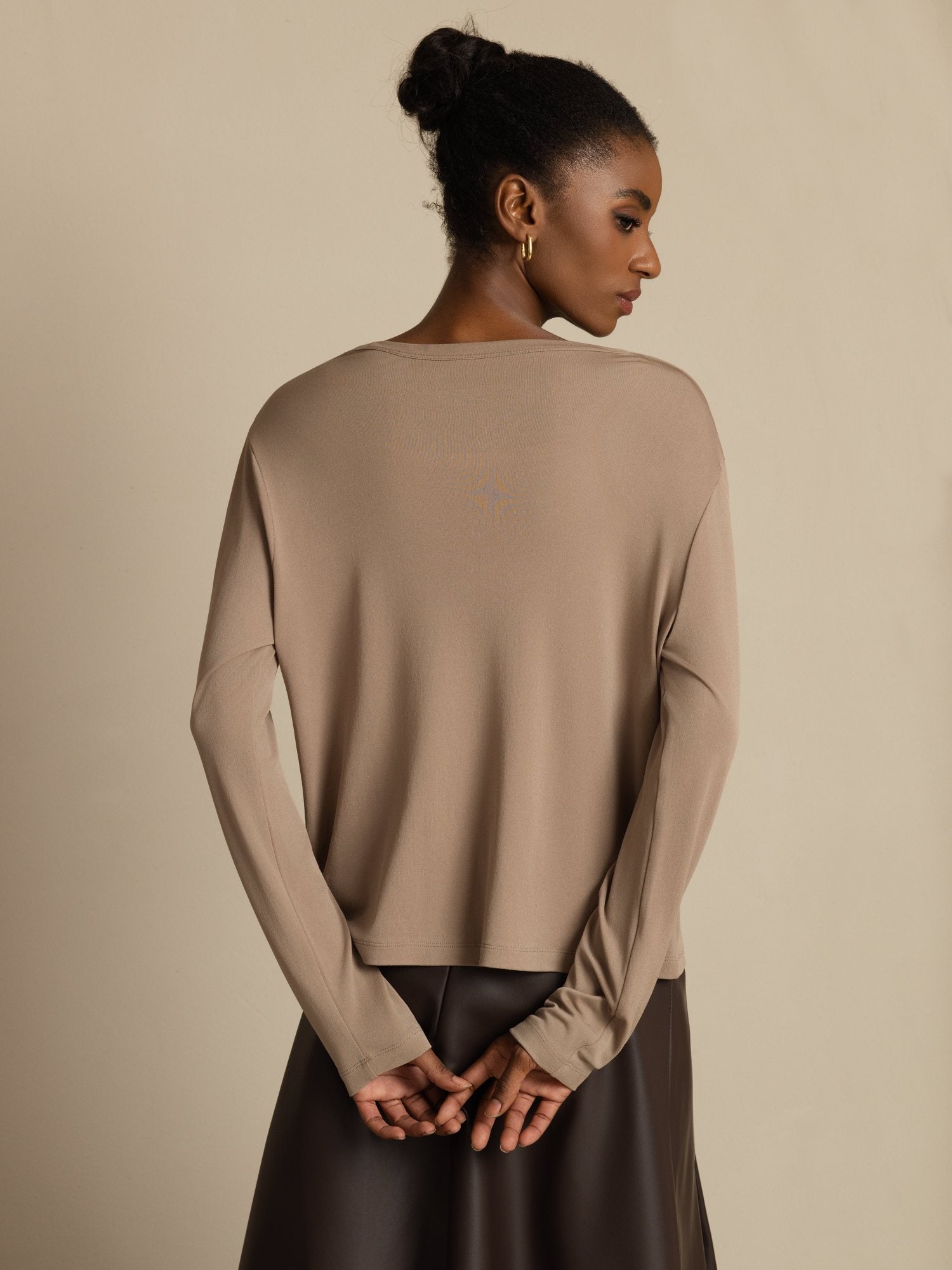 Model wearing beige 100% mulberry silk V-neck long sleeve cardigan, back view