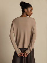 Model wearing beige 100% mulberry silk V-neck long sleeve cardigan, back view